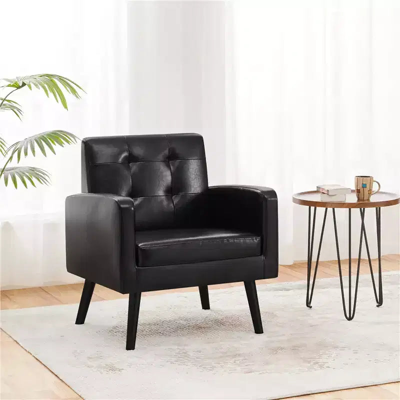 Poltrona moderna in similpelle trapuntata con gambe in legno massello